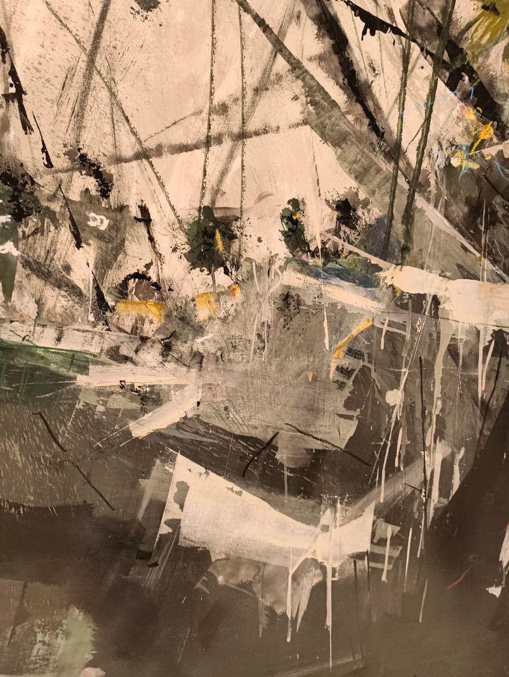 Dettaglio di pittura astratta: campiture color crema attraversate da segni neri e tocchi di giallo